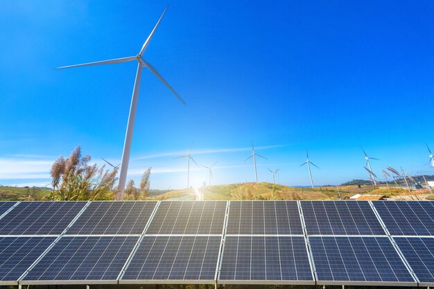 View of wind turbines and solar panels on field against sky