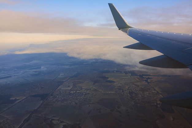 View to the wing of airplane in the sky Travel and transportation concept