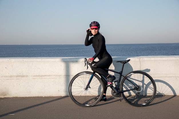 View of woman athlete cyclist on the waterfront