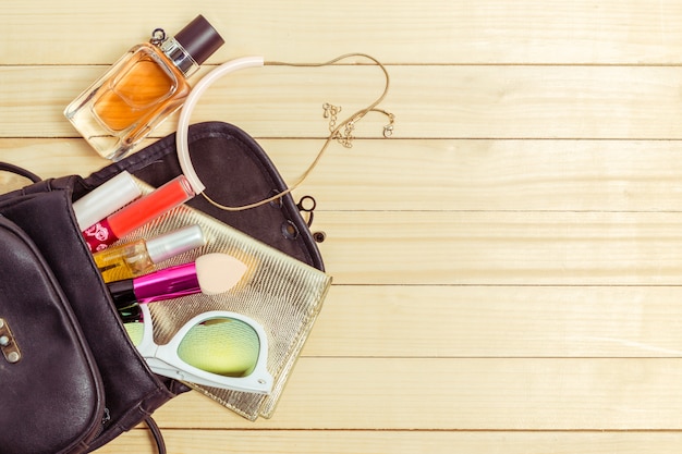 View on women bag stuff on wooden background