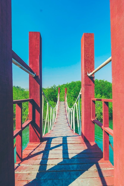 View of wooden bridge against clear blue sky