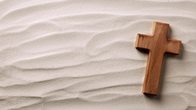 Above view wooden cross on sand