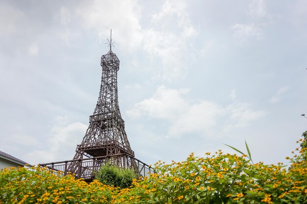 View of wooden eiffel tower replica in flower garden imitated eiffel tower made of wood in a grove in a flower garden