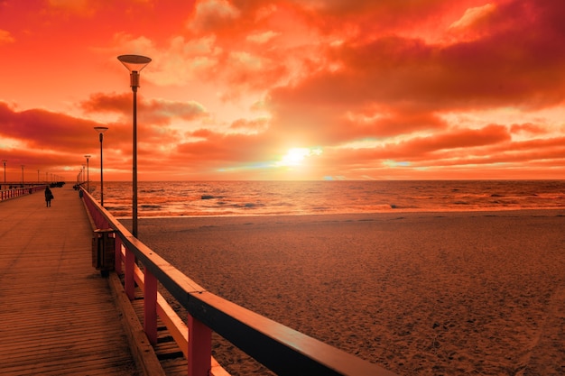 View of wooden pier over sea. Palanga city at sunset in autumn, Lithuania