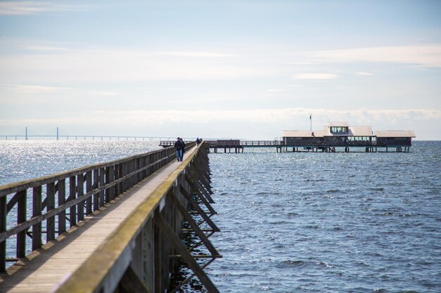 View of a wooden pier that goes into the North sea to the restaurant on a cloudy day