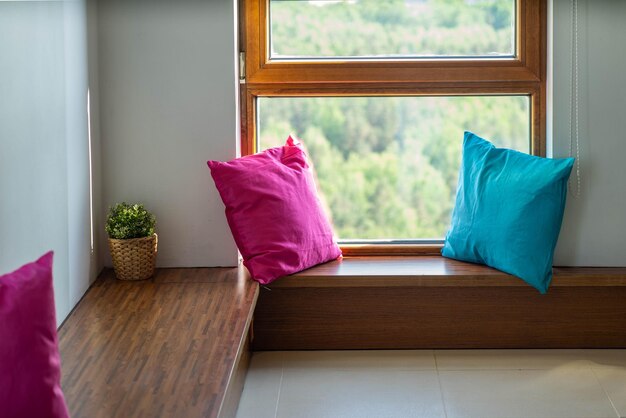 View of wooden windowsill with pillows and window Nice view Corner of the room