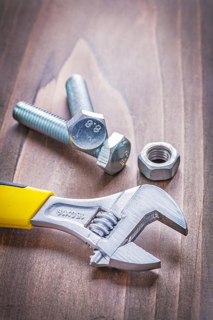 View on wrench and bolts on vintage wooden board construction concept