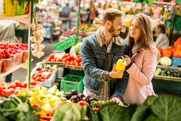 View at young couple buying vegetables on a market