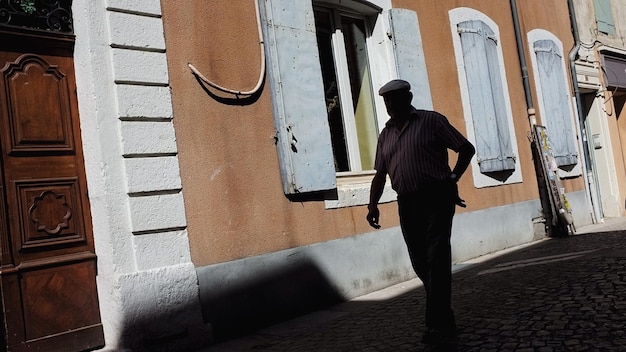 Photo view of a young man standing on wall