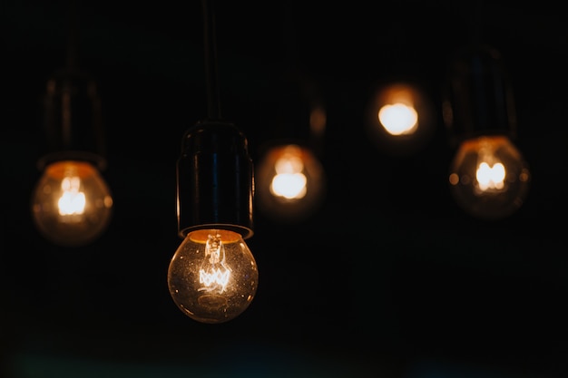 Vijf hangende brandende lichten voor interieurdecoratie schitteren in het donker.