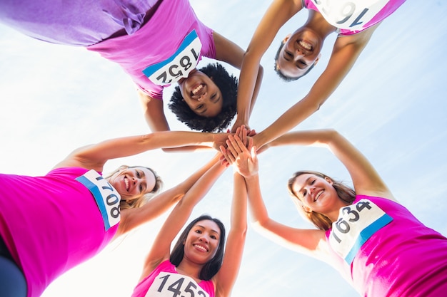 Vijf lachende hardlopers die de marathon van borstkanker ondersteunen