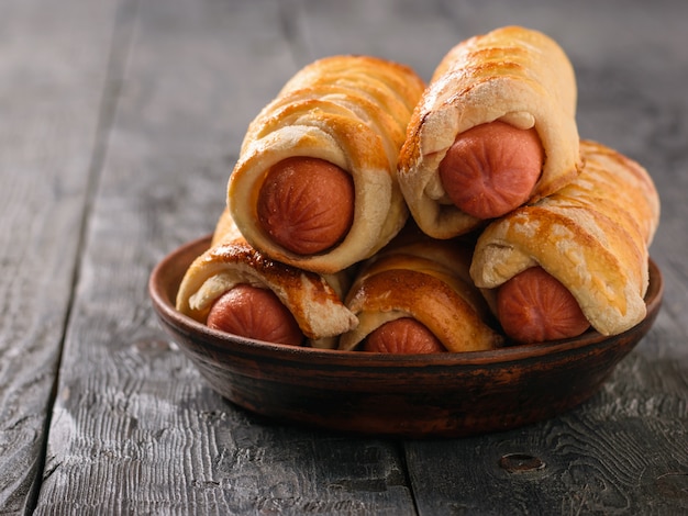 Vijf verse, zelfgemaakte varkens in een deken op de zwarte houten tafel.