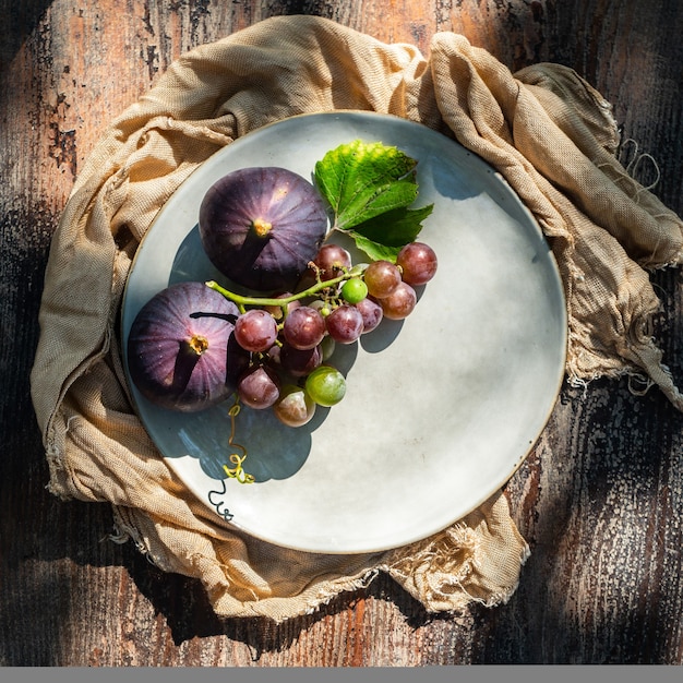 Vijgen en druiven in een bord op een houten tafel