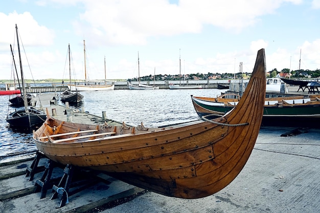 Foto barca vichinga che fa barca di legno sulla riva