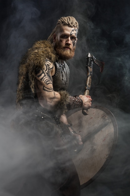 Foto viking gekleed in de huid van een beer met een bijl