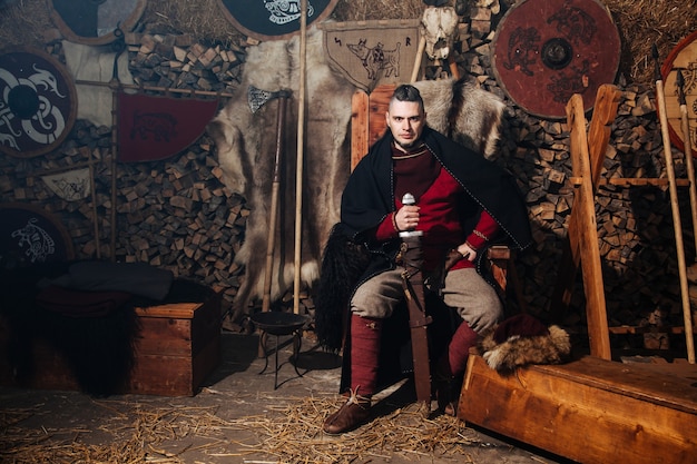 Photo viking posing against the ancient interior of the vikings.