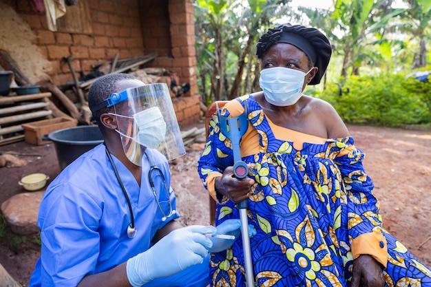 Photo the village doctor visits a sick old woman and gives her an injection