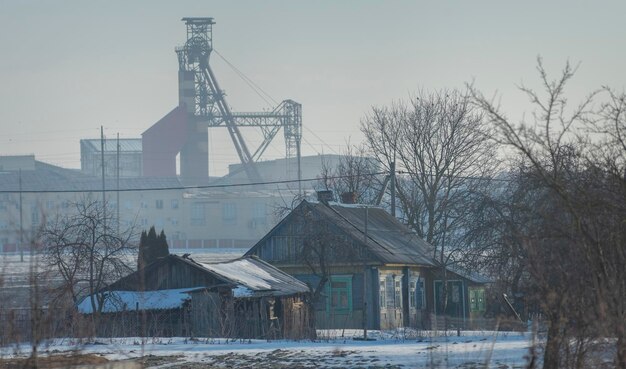 Village house on the background of an industrial factory