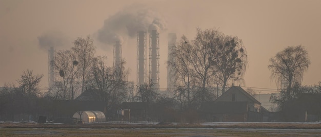 Village house on the background of an industrial factory