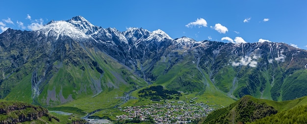 Village on snowcapped peaks of mountains Background In Kazbegi District MilitaryGeorgian road