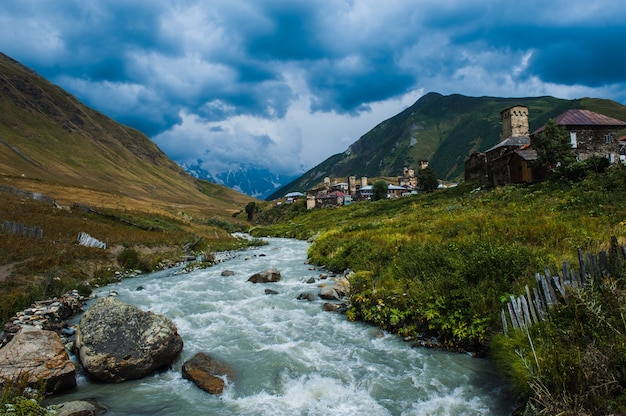 Village Ushguli landscape with massive rocky mountains Bezengi wall, Shkhara on the background in Svaneti, Georgia