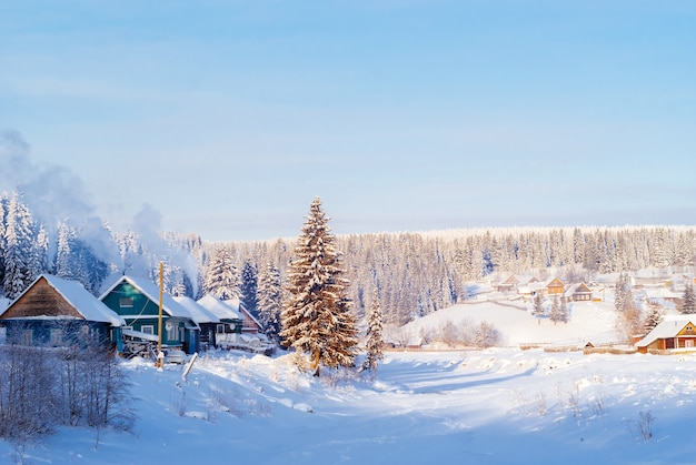 village in a winter valley on the bank of a frozen river on a frosty clear day