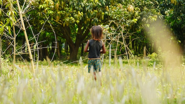 a villager kid stands in the field