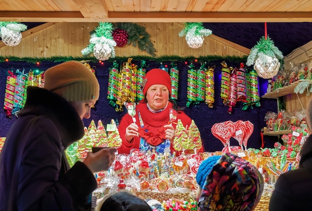 Vilnius, Lithuania - December 27, 2015: Seller and buyers at the Stall with traditional colorful and festive candies at the Christmas Market in Vilnius, Lithuania.