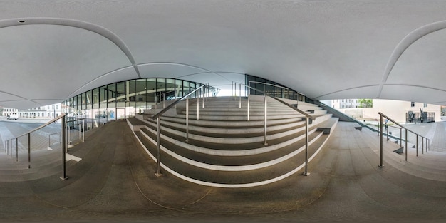 ВИЛЬНЮС, ЛИТВА, МАЙ 2019 г. Полная сферическая бесшовная панорама под углом 360 градусов возле фасада кривого современного здания с огромным зеркальным стеклом с лестницей в равнопрямоугольной проекции VR-контент