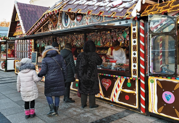 Vilnius, Litouwen - 4 December 2016: Familie bij het snoephuis van Kerstmis op de kerstmarkt op het Kathedraalplein, Vilnius in Litouwen.