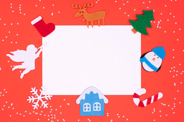 Vilten speelgoed voor het versieren van een kerstboom op een rode achtergrond met een plek voor tekst.