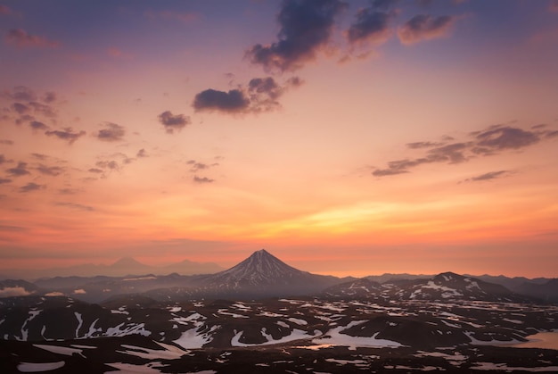 Vilyuchinsky volcano at sunrise. Kamchatka peninsula, Russia. Pink sky and snow covered mountains. Beautiful summer landscape