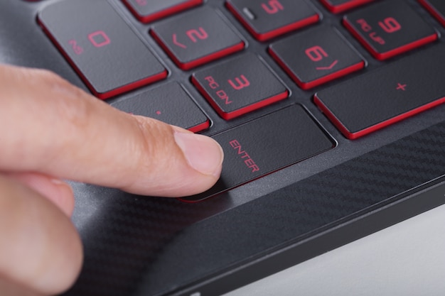 vinger drukken enter-knop op laptop toetsenbord