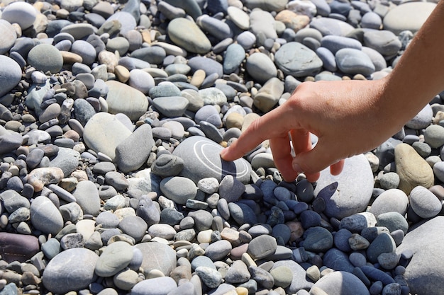 Vinger drukt op een ongebruikelijke steen alsof je op een knop drukt