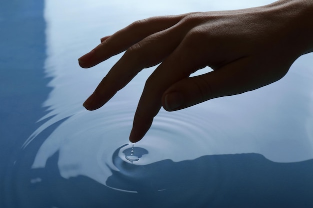 Vinger raakt water van dichtbij aan