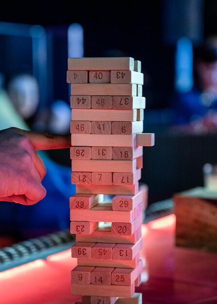 Vinger spelen de toren van houten blokken spel op tafel