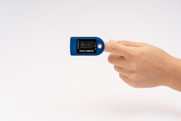 Vingertop-pulsoximeter op de vinger. Op witte achtergrond. Apparaat voor zelfdiagnostiek.
