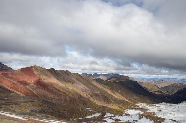 Vinikunka rainbow sette colori dovuti ai minerali della montagna una giornata nuvolosa vilcanota e una vigogna che cammina