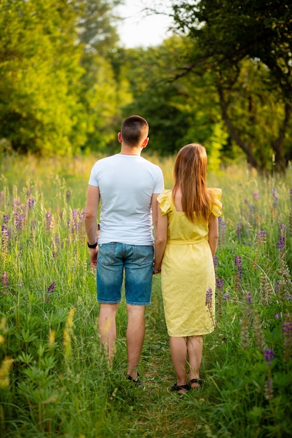 Vinnytsia, Oekraïne 10 juni 2022 Een mooi stel houdt elkaars hand vast en kijkt naar lupines in het park