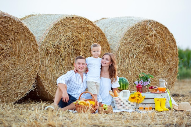 Vinnytsia Ukraine August 2 2022 A young family with a child on a picnic in a field near hay bales