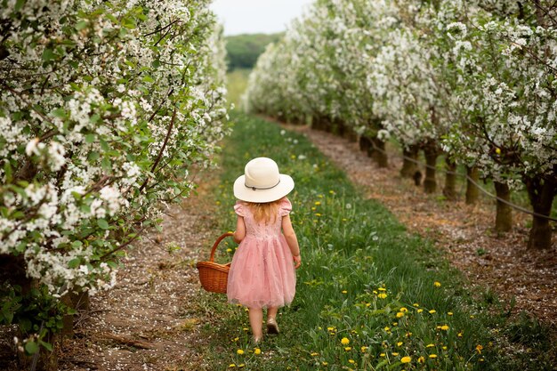Vinnytsia 우크라이나 2021년 5월 18일 어린 소녀가 정원에서 바구니를 가지고 걷습니다.