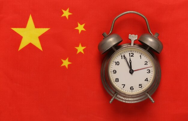 Vintage alarm clock on background of China flag