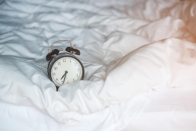 Vintage alarm clock on bed and copy space for text Wake up sleeping daily routine morning workout and Work life balance concept