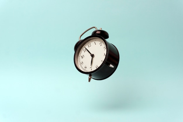 Vintage alarm clock on a blue clean background. 