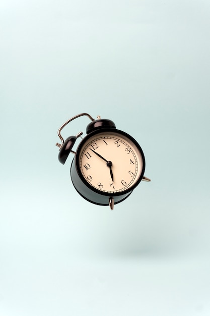 Vintage alarm clock on a blue clean background. 