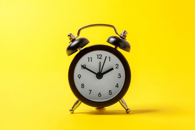 Vintage alarm clock Isolated on yellow background