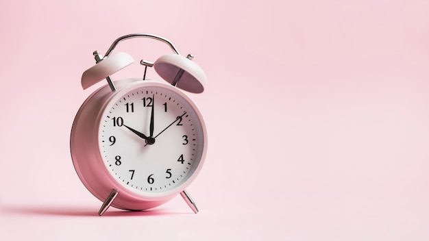 Photo vintage alarm clock on pink background