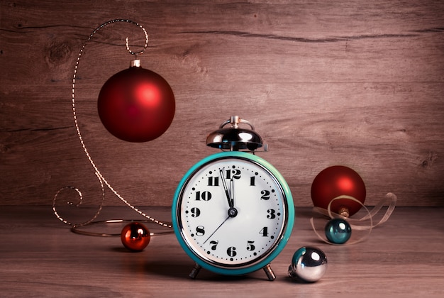 Vintage alarm clock showing five to twelve with Christmas baubles