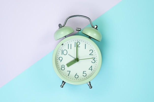 Photo vintage alarm clock on sweet pastel pape