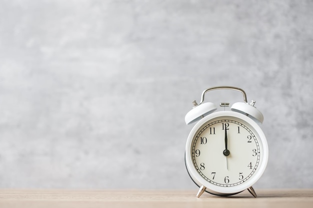 Vintage alarm clock on wooden table background and copy space for text. Activity, daily routine, morning, countdown, workout and Work life balance concept